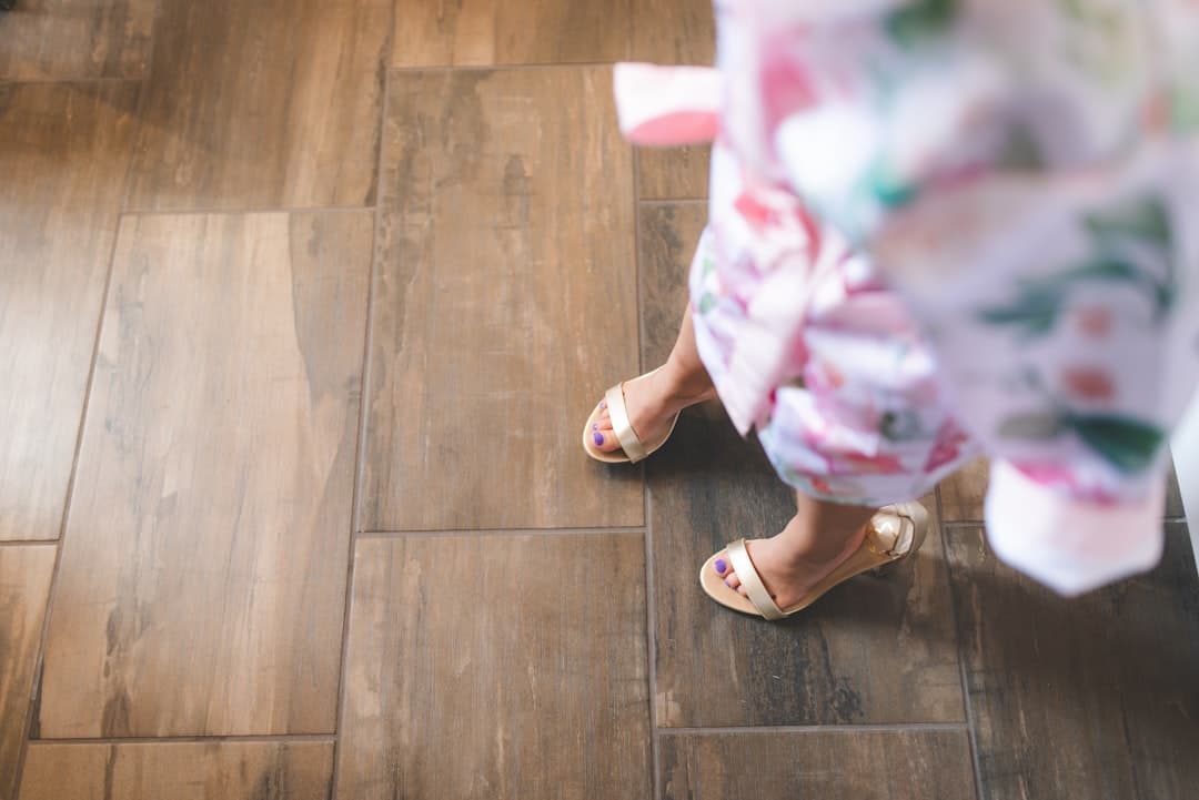 person in white and pink floral skirt standing on brown wooden floor — Photo by Stephen Andrews on Unsplash